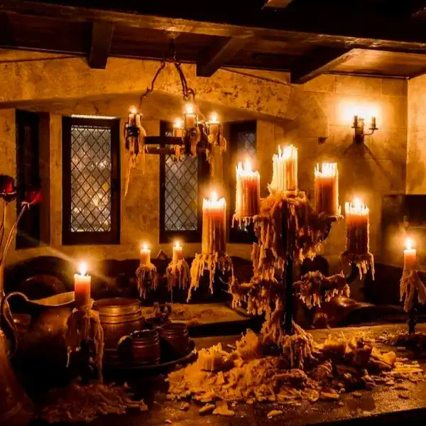 a dark room lit by many candles