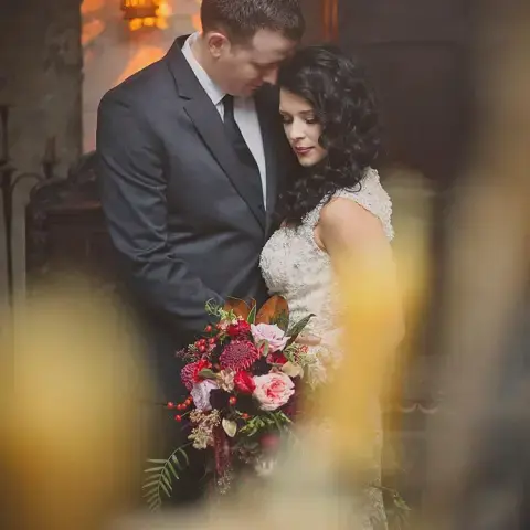 a man and a woman standing in front of a flower